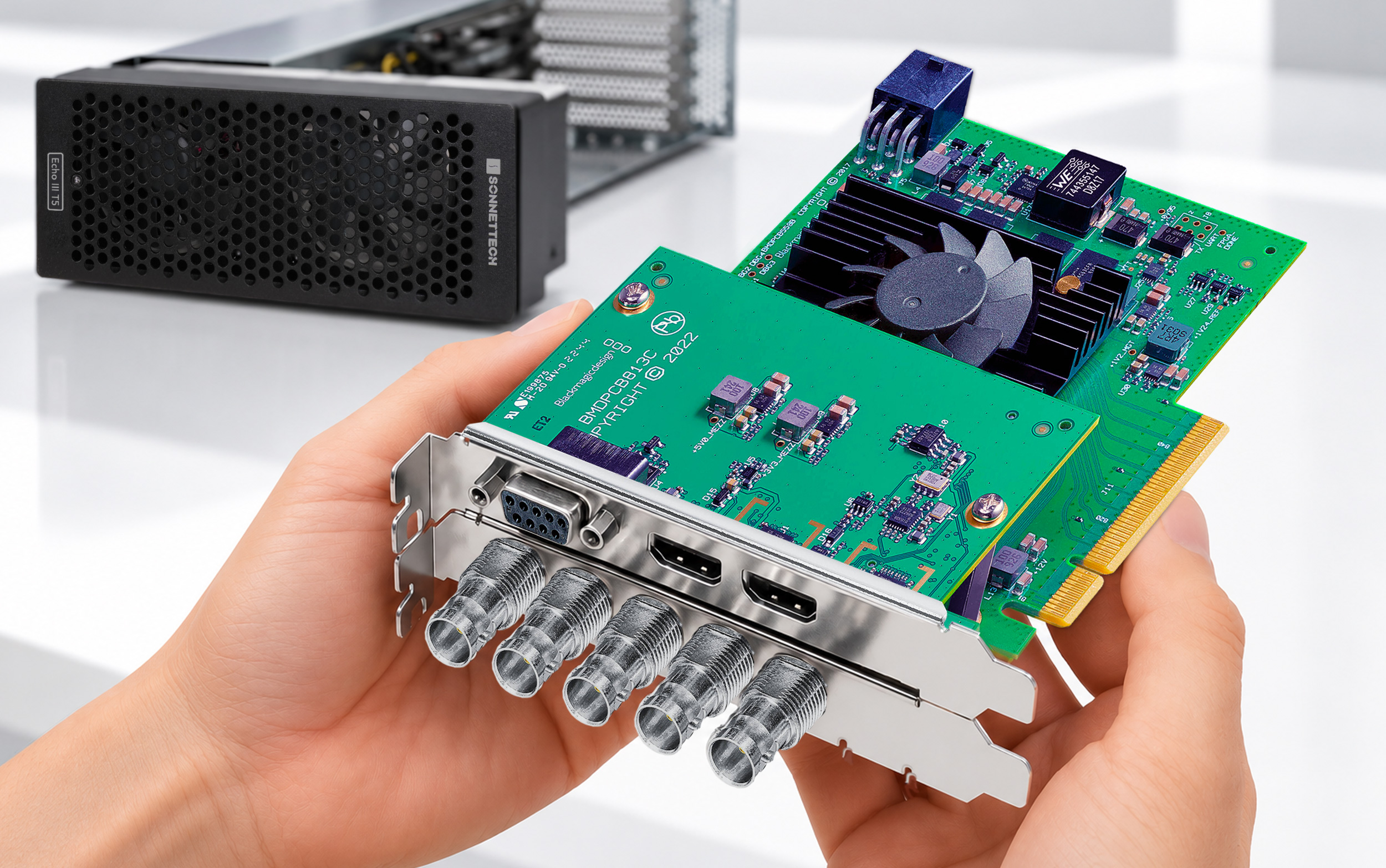 Pair of hands holding a Blackmagicdesign video PCIe card.