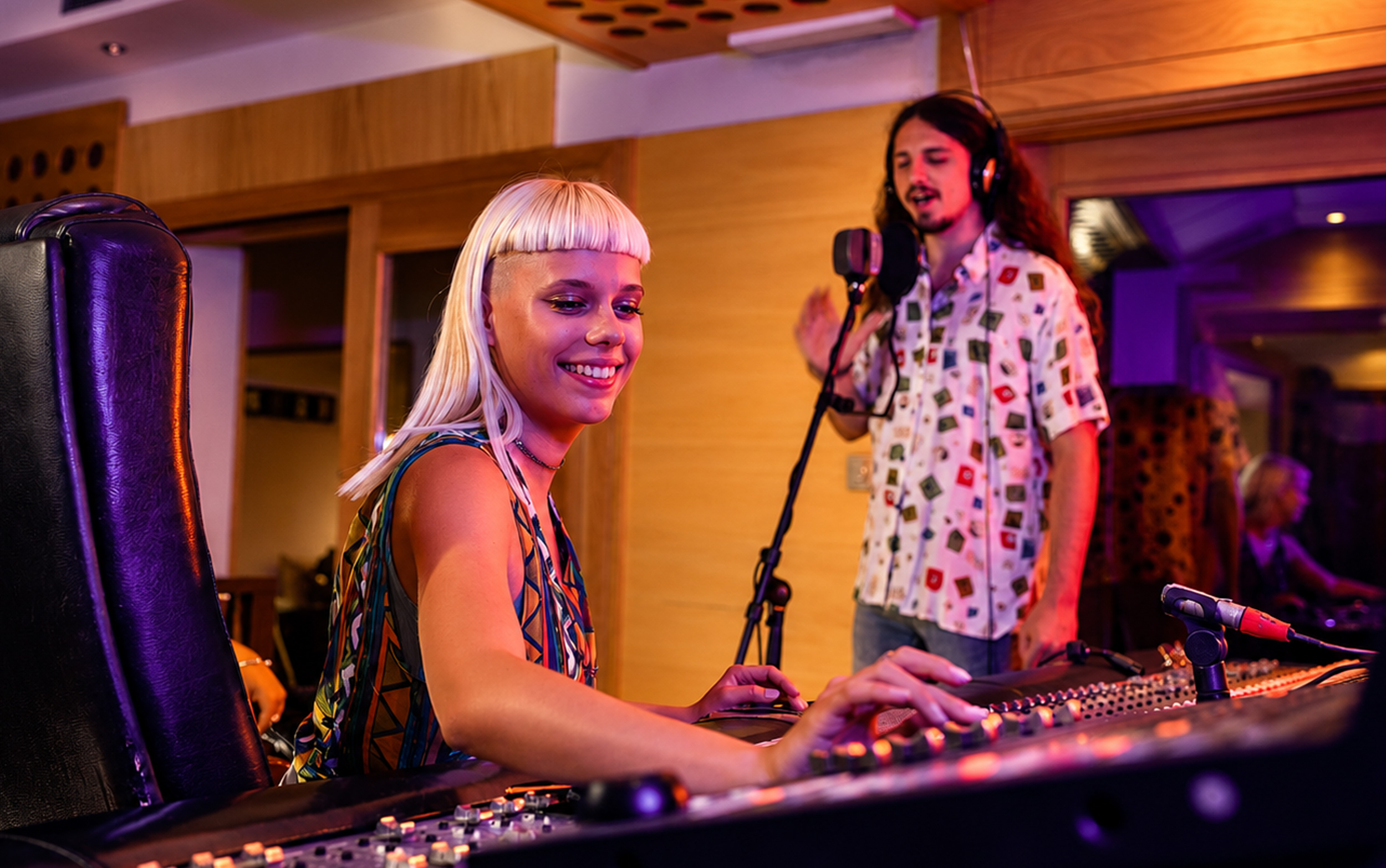 Audio engineer with singer in recording studio.