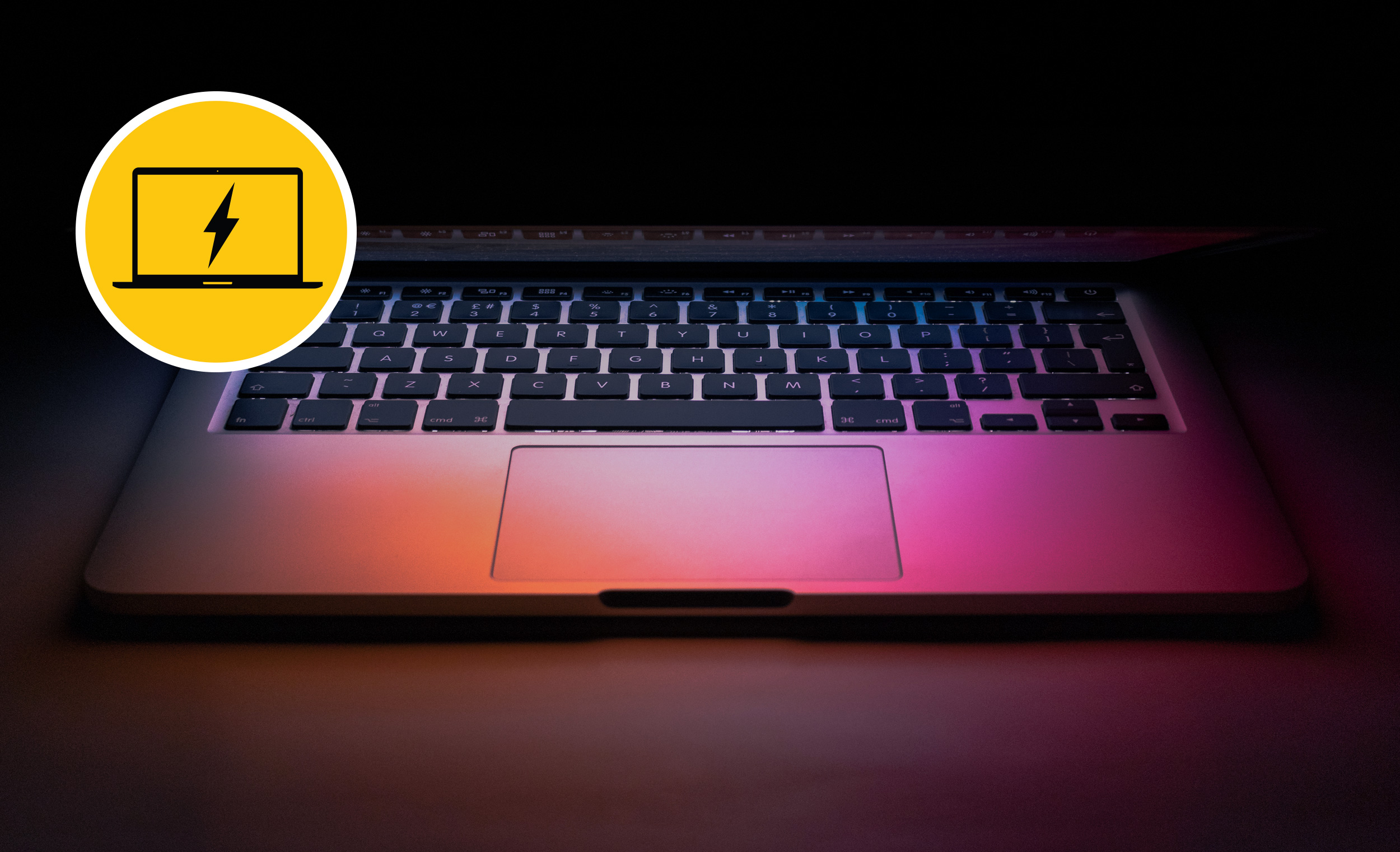 Apple MacBook Pro slightly open with screen glowing on keyboard.