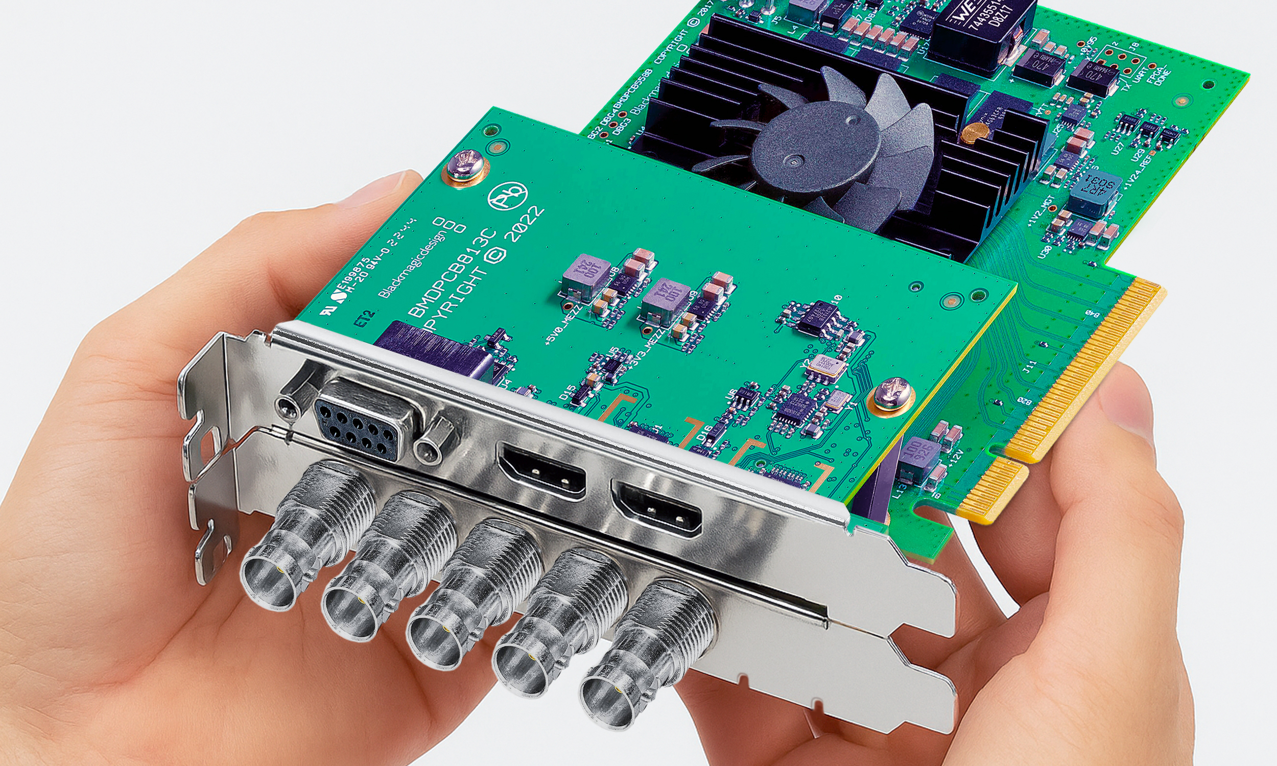 Pair of hands holding a Blackmagicdesign video PCIe card.