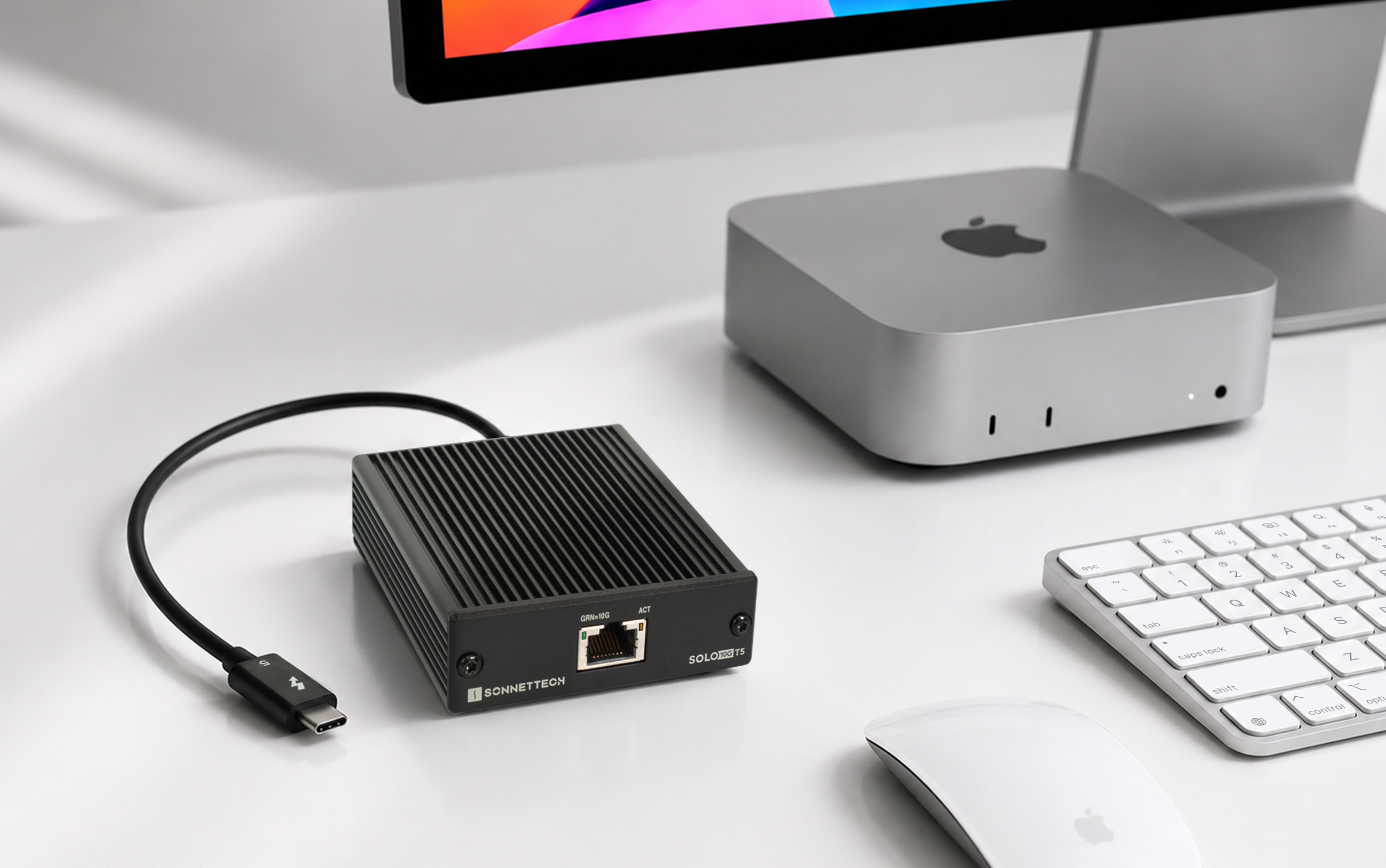 Solo10G T5 adapter next to desktop with Mac mini.